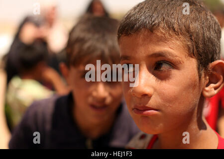 Kinder warten geduldig auf ihre Namen während einer Mission, humanitäre Hilfe, unterstützt durch US-Soldaten zugewiesen Golf Batterie, 82. Feldartillerie-Regiment, 3. Bataillon, 2nd Brigade Combat Team, 1. Kavallerie-Division in Adalla, Irak, Aug. 9 aufgerufen werden. Humanitären Hilfe Mission 195287 Stockfoto