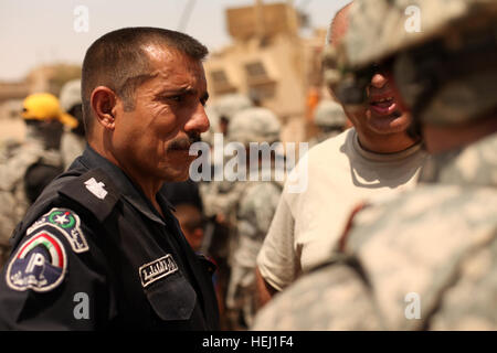 Der örtliche Polizeichef spricht mit US-Soldaten, Golf Batterie, 82. Feldartillerie-Regiment, 3. Bataillon, 2nd Brigade Combat Team, 1. Kavallerie-Division, während einer Mission der humanitären Hilfe in Adalla, Irak, Aug. 9 zugewiesen. Humanitären Hilfe Mission 195288 Stockfoto