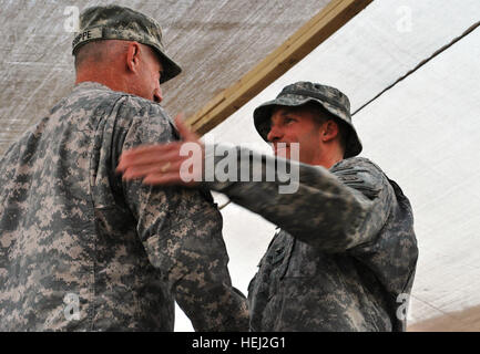 Neu gefördert Oberst Dave Buckingham (rechts), Manns Wahl, PA., dank Command Sergeant Major Frank Grippe, der Multi-National Corps - Irak, nach Grippe Buckinghams Kopfbedeckungen mit seinem neuen Rang, 1. Sept. um Combat Outpost Cashe Süd, Irak, befindet sich in der Ma'dain Region außerhalb der östlichen Bagdad zog. Grippe, diente als Buckinghams First Sergeant während wenn Buckingham als Kompaniechef im 75th Ranger Regiment diente. Buckingham dankte Grippe für seine Führung im Laufe der Jahre und seine Freundschaft. Buckingham dient heute als Kommandeur der 5. Staffel, 73. Kavallerie-Regiment, 3. Brig Stockfoto