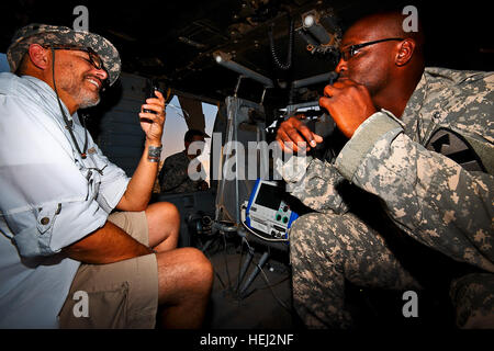 Während sitzen in einem UH-60 Black Hawk Medevac-Hubschrauber, Sgt. 1. Klasse Cleron, rechts, Washington von Walter Berg, S.C., der Flug Medic Unteroffizier verantwortlich für Unternehmen C, 2. Bataillon, 227. Aviation Regiment, 1st Air-Kavallerie-Brigade, 1. Kavallerie-Division, Multi-National Division - Bagdad, gibt Schauspieler Joe Pantoliano, links, eine Vorstellung davon, wie eine Medevac-Einheit arbeitet, Camp Taji, Irak , September 5. Joe, lebt mit Depression, hierher zur Förderung der Bekanntheit von psychischen Erkrankungen und verschiedene Möglichkeiten, damit umzugehen. Tour hilft, "das Stigma aus Geisteskrankheit 202049 stampfen" Stockfoto