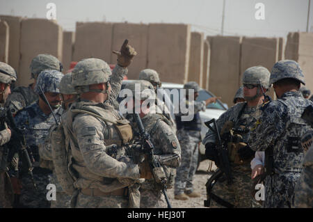 US Army Staff Sgt Robert Barry aus Cassapolis, Michigan, und andere Soldaten befestigt an 2nd Platoon, Alpha-Truppe, 5. der 73. Cavalry Squadron, Brigade spezielle Truppen Bataillon, 82. US-Luftlandedivision, begeben Sie sich mit den Mitgliedern des irakischen nationalen Polizei Befehls, als sie zu einem Markt außerhalb der Forward Operating Base Salie in Bagdad Generalleutnant Charles Jacoby, Kommandierender general, Multi-National Corps - Irak, escort , Irak, 9. September 2009. Operation Iraqi Freedom 207540 Stockfoto