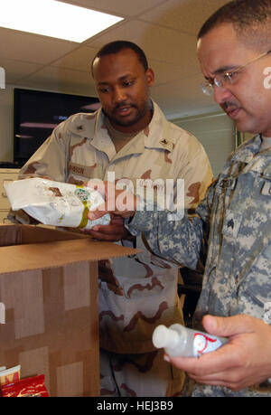 GUANTANAMO BAY auf Kuba – Navy Petty Officer 3rd Class Willie Johnson, Auszeichnungen Sachbearbeiter für das Joint-Personal-Service-Center verteilt ein Paket von Starbucks Coffee gespendet von "Unterstützung der Truppen" zur Armee Sgt. Jaime Concepcion, eine Kommunikation Unteroffizier mit Puerto Rico National Guard 480th Military Police Battalion, am Joint Task Force Guantanamo j-1 einen Stop in Camp America, Sept. 15 , 2009.  Die JPSC Verwaltung unterstützt und Prozesse lassen Dokumente für JTF Guantanamo-Service-Mitglieder. JTF Guantanamo führt sicher, humane, rechtliche und transparente Betreuung ein Stockfoto