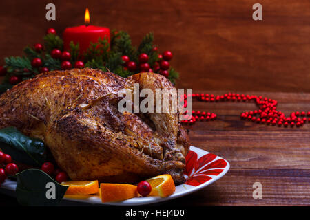 Ganze Brathähnchen mit Weihnachtsdekoration. Hölzerne Hintergrund. Stockfoto