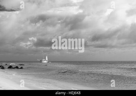 Bild zeigt ein großes Segelboot am Meer navigieren in Richtung Strand. Das Bild wurde aufgenommen von Arashi Beach, Aruba in der Karibik. Stockfoto