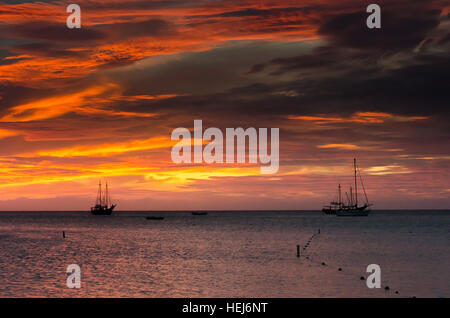 Bild zeigt die goldene Stunde mit Segelbooten am Meer durch den Sonnenuntergang verankert. Das Bild wurde aufgenommen in Aruba in der Karibik. Stockfoto