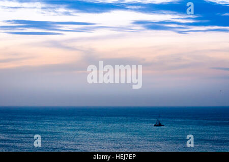 Dämmerung auf hoher See mit Schifffahrt Boot Silhouette im blauen karibischen Meer in Aruba Stockfoto