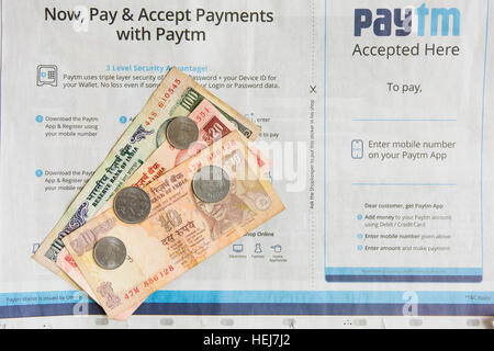 HYDERABAD, Indien - Dezember 22,2016 Zahlungen mit Paytm Zeitungsanzeige in Indien, indischer 100 Rupie-Banknoten und-Münzen Stockfoto