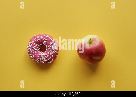 Apple und Donut in Bildmitte Stockfoto