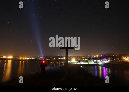 Eine sternenklare Nacht als Weihnachtsbeleuchtung spiegeln sich im Wasser am Alnmouth in Northumberland mit St Cuthberts Kreuz im Vordergrund. Stockfoto