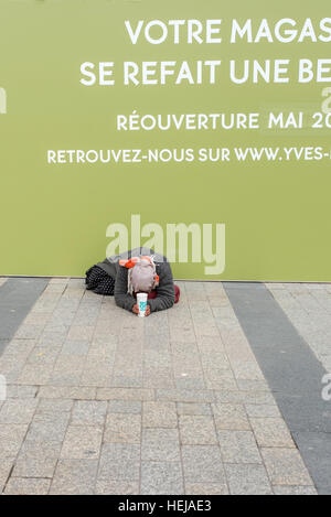 Eine Obdachlose Frau Betteln auf der Straße in Paris vor einem Geschäft renoviert. Stockfoto