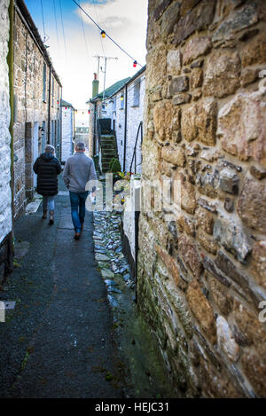 Ein paar auf der malerischen malerischen Ente Straße im historischen Dorf von Mousehole, Cornwall. Stockfoto