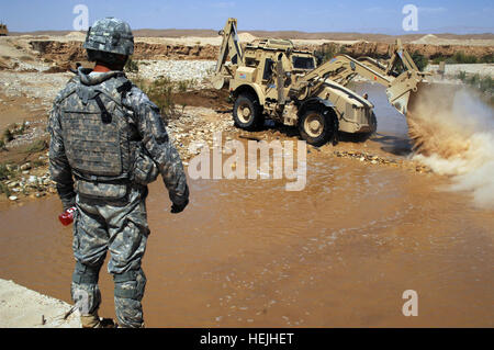 Ein US-Soldat aus 1. Platoon, Charlie Kompanie, 9. Pionier-Bataillon, beobachtet, wie Kies in den Fluss zu einer Furt über einen Fluss in der Nähe der Grenze zu Irak-Iran, 22. September 2009 gekippt wird. Eine Brücke über den Bach hatte durch den letzten Regen weggespült und die Ford ermöglicht militärischen Übergang Teams, Ausbildung mit irakischen Grenzsoldaten durchzuführen. Ford Gebäude 206648 Stockfoto