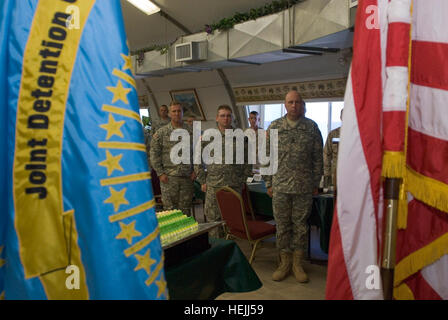 Armee Oberst Bruce Vargo, Kommandeur der gemeinsamen Haft Gruppe zugewiesen Joint Task Force Guantanamo, Pvt. John Grauer und Command Sergeant Major Steven Raines, Befehl Sergeant-Major der 525th Military Police Battalion, stehen stramm während des Abspielens der Nationalhymne im Rahmen einer Feierstunde zum Gedenken an den MP Regimental Geburtstag, 25. September 2009. Der MP-Zweig wurde offiziell anerkannt von der Armee am 26. September 1941, und zählt zu einer der am meisten eingesetzten Zweige, nachgestellte nur der Special Forces. JTF Guantanamo durchführt, sichere, humane, rechtliche und transparente Betreuung und Sorgerecht für sein Stockfoto