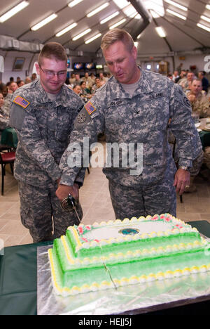 Pvt. Armee John Grauer und Armee Oberst Bruce Vargo, Kommandant des Arbeitskreises gemeinsame Haft schneiden einen Kuchen zu Ehren von der Militärpolizei 68. Regimental Geburtstag in Joint Task Force Guantanamo, 25. September 2009. Der MP-Zweig wurde offiziell anerkannt von der Armee am 26. September 1941, und zählt zu einer der am meisten eingesetzten Zweige, nachgestellte nur der Special Forces. JTF Guantanamo führt sicher, humane, rechtliche und transparente Pflege und Obhut der Gefangenen, einschließlich der Militärkommission und die verurteilten bestellt von einem Gericht freigegeben. Die JTF führt Intelligenzansammlung, Analyse und Themensammlung Stockfoto