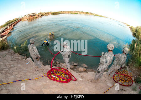 Taucher mit dem 86. Ingenieur Dive Team beenden des Euphrats nach einem zweistündigen Tauchgang, Ablagerungen in den Pfad der neuen Saqlawiya Brücke nördlich von Al Taqaddum, Irak, 5. Oktober 2009 zu finden. Die "Nabelschnur" wird umhüllt von Ufer Personal umfasst die Taucher Luftzufuhr und Kommunikation. (Foto: U.S. Army Spc. Michael J. MacLeod) (freigegeben) "Beraten und unterstützen" Brigade der US-Armee 53133 hilft Brückenprojekt Stockfoto