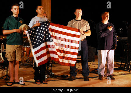 (links nach rechts) Marine Sgt. John Eubanks, Atlanta, Georgia;  Armee CPL Craig Chavez, Temecula, Kalifornien; Army Staff Sgt Luke Wilson, Hermiston, Oregon/USA; und Armee Sgt. Ethan Payton, Milford, NJ, stehen mit der US-Flagge Okt. 16, während anderen verwundeten Krieger, Armee Sgt. John Hyland von Charlotte, N.C., während ein Barbecue am Camp Sieg in Bagdad die Nationalhymne singt. Der Grill war die letzte Veranstaltung für acht verwundete Kriegsveteranen Betrieb richtige Ausfahrt teilgenommen. Das Programm ermöglicht verletzte Servicemembers zurück in den Irak für eine einwöchige Reise an die Orte zu besuchen, die sie verletzt wurden. US-Ar Stockfoto