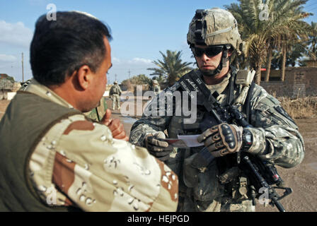 Staff Sgt Aaron Burlingame, Einsatzleiter in Firma A, 2. Bataillon, 23. Infanterie-Regiment, 4. Stryker Brigade Combat Team, 2. US-Infanteriedivision aus Fort Lewis, Washington, prüft die Identifizierung eines Sohn des Irak in der Nähe von Muqdadiyah, Irak, 1. Februar. 2-23 INF arbeitet mit Söhnen des Irak 76266 Stockfoto