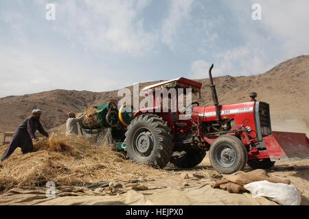 Afghanische Dorfbewohner Schleifen Stroh während der US-Marines von Embedded Training Team 1-12 Soldaten der afghanischen Nationalarmee und US-Armeesoldaten patrouillieren der Depak-Tal, Afghanistan, 30. Oktober 2009. (US Armee-Foto von Sgt. Teddy Wade/freigegeben) Afghanische Landarbeiter in 2009 Stockfoto