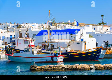 Angelboote/Fischerboote ankern vor einer kleinen Kirche in Naoussa Hafen, Insel Paros, Griechenland Stockfoto