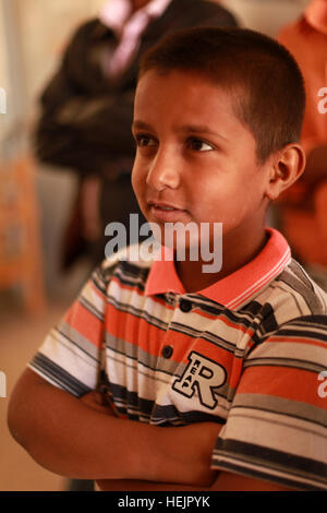 Ein Kind faltet seine Arme, als US-Soldaten von Bravo Batterie, 3. Bataillon, 82. Feldartillerie-Regiment, 2nd Brigade Combat Team, 1. Kavallerie-Division und irakische Soldaten verteilen humanitären Hilfe für die Bürger von Adalla, Irak, 31. Oktober 2009. Operation Iraqi Freedom 221323 Stockfoto