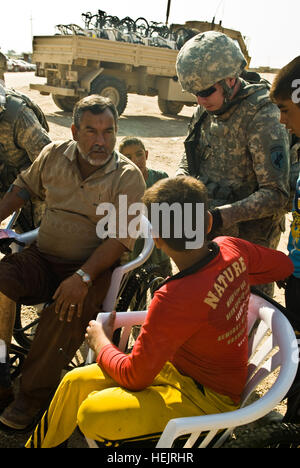 Staff Sgt Michael Hawf von St. Louis spricht mit einem irakischen Jungen und ein irakischer Mann, die sowohl Rollstühle von Soldaten des 1. Bataillons der West Virginia Nationalgarde, 150. Armored Reconnaissance Squadron, 30. Heavy Brigade Combat Team, während eine zentrale Führung Engagements in Yusifiya, Irak, am 11. November zu erhalten. Hawf erhält Civil Affairs Team 722, 30. HBCT zugewiesen. Die Rollstühle wurden gespendet von einer gemeinnützigen Organisation in den Vereinigten Staaten. Rollstühle, Yusifiya 222719 Stockfoto