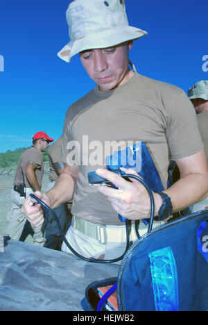 Coast Guard Petty Officer 2. Klasse Sal Hernandez, ein Mitglied der Seeverkehrssicherheit und Sicherheitsteam 91103, sorgt für einwandfreie Funktion der ein Blutdruckmessgerät vor ein m-16 Gewehr Qualifikation natürlich, 14. Dezember 2009. Hernandez war der Bereich Rettungssanitäter, medizinische Hilfe bei Notfällen leisten. MSST 91103 wird hier eingesetzt, um maritime Anti-Terror und Gewalt Schutz Pflichten für Joint Task Force Guantanamo. MSST 91103 reichen 233626 Stockfoto