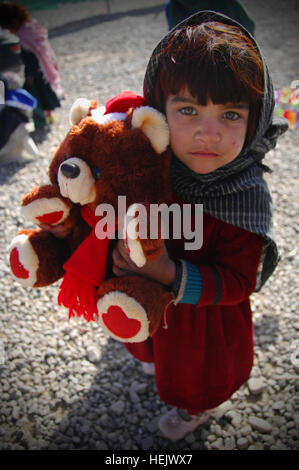 Afghanische Mädchen ballt ihr Teddy Bär, die sie in der Medicl Klinik während ihrem Besuch, Camp Clark, Khowst Provinz, Afghanistan, 22. Dezember 2009 erhalten. Die Klinik unterstützt lokale afghanische Kinder im Bereich Bereitstellung von Vitaminen und Winterbekleidung. Humanitäre Hilfe 243982 Stockfoto