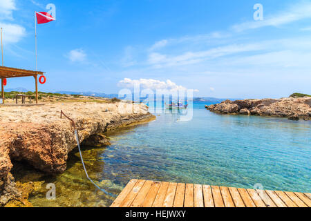 Holzmole in kleinen Meer Bucht mit Angeln Boot im Hintergrund, Insel Paros, Griechenland Stockfoto