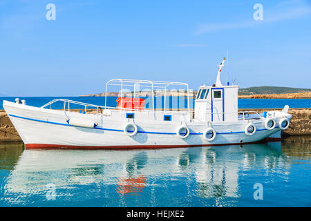 Traditionelle weiße Fischerboot und seine Spiegelung im Wasser, Naoussa Hafen auf der Insel Paros, Griechenland Stockfoto