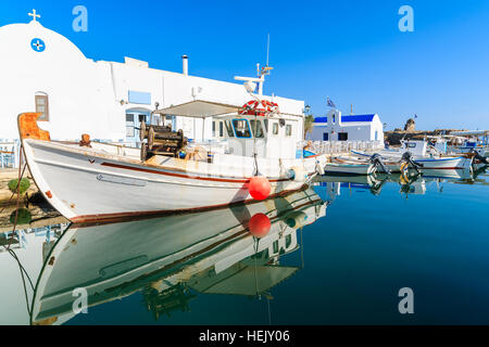 Angelboot/Fischerboot Liegeplatz vor einer kleinen Kapelle in Naoussa Hafen, Insel Paros, Griechenland Stockfoto