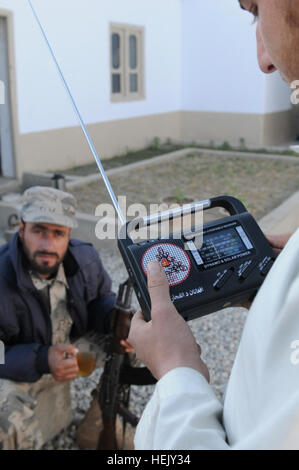 NANGARHAR, Afghanistan (18. Januar 2010) - 100118-A-3421S-218: SHINWAR Provinz, Afghanistan – auf der Suche nach einen neuen Radiosender Shinwar Bezirk einen jungen Afghanen, mit Hilfe der afghanischen Grenze Polizei Offizier, manipuliert das Zifferblatt von einer Handkurbel Radio von afghanischen nationalen und Koalition Sicherheitskräfte verteilt.  Radios und neue Radiosender sind Teil einer Medien-Informationen-Initiative gefördert durch die International Security Assistance Force [ISAF] Aufstandsbekämpfung Programm. Georgiens Armee Nationalgardisten des 1st Squadron, 108. Kavallerie-Regiment, Task Force Mountain Krieger haben o Stockfoto