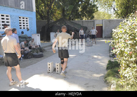 Soldaten aus dem 2nd Brigade Combat Team (Falken), 82. US-Luftlandedivision, spielen eine hausgemachte Spiel namens "Mais Loch" in Port-au-Prince, Haiti, 29. Januar 2010. Die 2. BCT auf Haiti zur Unterstützung der Operation Unified Reaktion auf die massiven abzusichern bereitgestellt wird humanitäre Bemühungen durchgeführt während der Erdbeben verwüsteten Land Haiti. Haiti Hilfsmaßnahmen 246250 Stockfoto