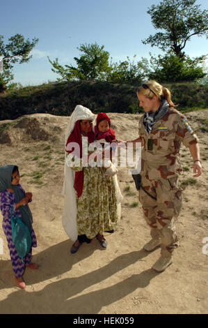 Schwedische Nationalarmee 1st Lt. Elisabeth Alm, militärische Beobachter Team Liaison Officer hilft Führer einheimischen Frauen und Kinder in Richtung der weiblichen medizinische Station während der medizinischen zivile Hilfe Programm (MEDCAP) im Dorf Stin, der Provinz Balkh, Afghanistan am 4. April 2006. Diese MEDCAP gliedert sich durch kombiniert Joint Special Operation Task Force - Afghanistan für Männer, Frauen und Kinder in der Provinz Balkh. (Foto: U.S. Army Spc. Michael Zuk) (Freigegeben) Schwedische militärische Beobachter Team Verbindungsoffizier in Afghanistan 2006 (2) Stockfoto