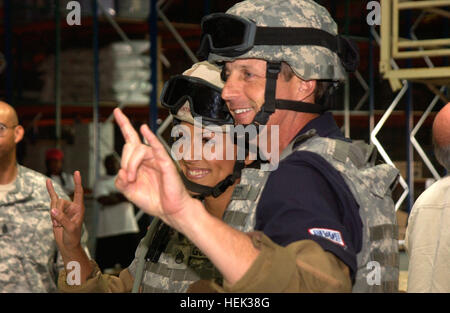 Leeann Tweeden, The Best Damn Sports Show Period-Korrespondent und Ric Barnes, University of Texas Herren College Basketball Coach, Signal 'em Hörner Haken"bei ihrer Vorbereitung auf den Humvee Egress Hilfe Trainer bei Camp Arifjan 27 Mai geben. Tweeden Barnes Stockfoto