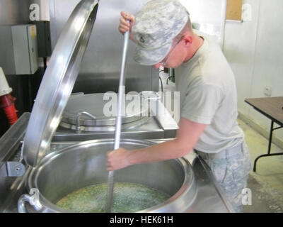 PFC Daniel Summey ein Food-Service-Spezialist mit nach vorn Unterstützungskompanie, 215. Brigade Support Battalion, 3. beraten und unterstützen Brigade, 1. Kavallerie-Division und gebürtig aus Charlotte, North Carolina, rührt einen riesigen Topf, wie er Nahrung für die hungrigen Soldaten auf Kontingenz Betrieb Station Garry Owen, Irak, Sept. 19 erwärmt. "Haudegen" erhält schlank; Armee-Köche ersetzen Auftragnehmer 462794 Stockfoto