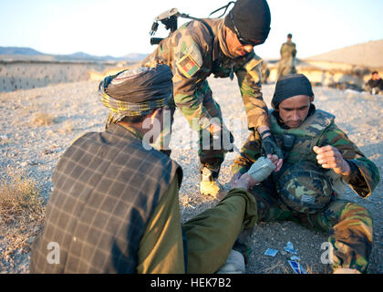 Afghanische Soldaten Sanitäter mit 3. Commando Kandak führen erste Hilfe auf ein Afghane verletzten Fuß, 7. November 2010, im Bezirk Arghistan, Provinz Kandahar, Afghanistan. Die Kommandos, unterstützt von Soldaten mit Special Operations Task Force - South, führen Operationen, um die Aufständischen aus der Region zu befreien. Die Verletzung war bereits vorhanden und nicht im Zusammenhang mit dem Betrieb. (US Army Foto von Daniel s. schüttelte/Special Operations Task Force - Süd) (Freigegeben). Afghanische Commandos Dorfbewohner Frieden finden in Kandahar 338378 Stockfoto
