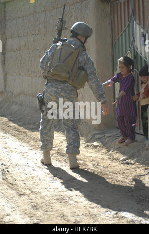 Major Mike Roth, Special Operations Task Force East, verteilt Süßigkeiten an Kinder während einer Patrouille von Jan Qadam Dorf, Bagram Bezirk, Parwan Provinz, Afghanistan November 10. SOTF-E Soldaten sprach mit den Anwohnern und Rapport mit dem Dorf, auf ältere, Frauen, Männer und Kinder gegründet. (Foto: U.S. Air Force 1.. Lt. Neil Samson) (Freigegeben) Jan Qadam Dorf Präsenz Patrouille 339076 Stockfoto