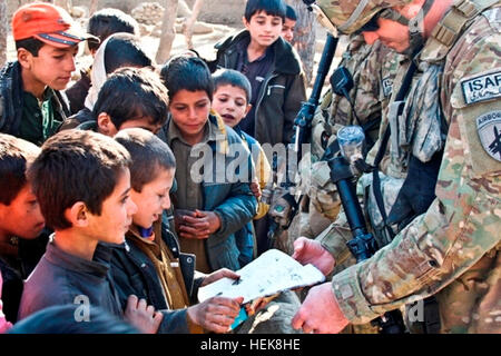 Provinz LAGHMAN, Afghanistan - US Armee Sgt. Toby Hall, zivile Angelegenheiten Teamleiter mit Firma A, 413th Civil Affairs Bataillon und gebürtig aus Amarillo, Texas, beobachtet, wie ein afghanischer junge englische Wörter für Bilder er rezitiert an in einem Schulbuch Jan. 10 in das Dorf Kotalay, Ostafghanistan Punkte. Kotalay ist einer der Hot Spots in der Provinz Laghman, für US- und afghanische nationale Armee-Soldaten gewesen. (Foto: U.S. Army Staff Sgt Ryan C. Matson, Task Force Red Bulls Public Affairs Office) Kotalay, ein Dorf in der Mitte 358519 gefangen Stockfoto