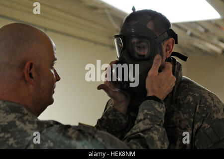 Staff Sgt Ronald Stephens, eine chemische biologische radiologische nuklearen NCO zugewiesen Headquarters und Headquarters Company, Brigade Truppen Bataillon, 1st Stryker Brigade Combat Team, 25. Infanterie-Division, Fort Wainwright, Alaska, sichert die Schutzmaske M41 Gas auf Spc. Thomas Hess, ein Geospatial Intelligence Specialist, von BTB, 1-25. Hess, gebürtig in Washington, District Of Columbia, gehört zu den vielen Soldaten-1-25. zugewiesen, die ihre Schutzmasken in Vorbereitung für die Bereitstellung von Soldaten, die National Training Center in Fort Irwin, Kalifornien und nächsten Monat erhalten. Stockfoto