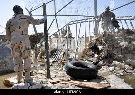 Rick Ferguson, Uhren links, als Sgt. 1. Klasse Candido Aguilar entfernt Schmutz von Wasserrost auf Kandahar Flugplatz, Afghanistan. (Foto von Mark Özdemir) FEST-M-Kämpfe in der Wüste 371571 Überschwemmungen Stockfoto