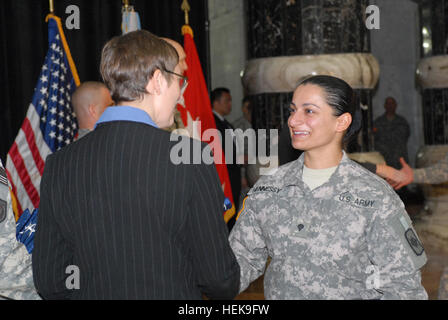 SPC. Rasha Hennessy, Linguist, 1. höhere Sitz Batterie, 1. Bataillon, 206. Feldartillerie, 39. Infantry Brigade Combat Team, erhält eine amerikanische Flagge von Lori Pietropaoli, stellvertretender Direktor, US Citizenship and Immigration Services, 4. November 2008 während einer US-Staatsbürgerschaft Zeremonie am Al-Faw-Palast auf dem Camp Victory, Irak. Hennessy geboren in Bagdad, nur Meilen von wo sie ihren Eid der US-Staatsbürgerschaft nahm. Service-Mitglieder werden US-Bürger am Wahltag 126324 Stockfoto