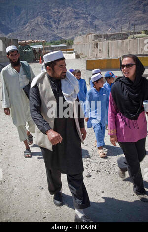 Der Anführer der US-Armee kulturelle Unterstützung Team 2 (CST)(right) Director of Education (Mitte) der Khas Kunar District und dem Auftraggeber (links) begrüßt von Tanar Grundschule mit afghanischen Studenten durch die Eintrag Kontrolle Punkt des Combat Outpost Penich, Provinz Kunar, Afghanistan, 14. Mai 2011. Der Regisseur und der Auftraggeber wurden zusammen mit den Studenten aus Tanar Grundschule eingeladen ein Kinotag, veranstaltet von der CST mit der Absicht, eine Beziehung aufbauen und Vertrauen mit den Khas Kunar Bezirksgemeinschaft. (US Army Foto von Pfc. Benjamin Tuck/nicht veröffentlicht) Operation Enduring Freedo Stockfoto