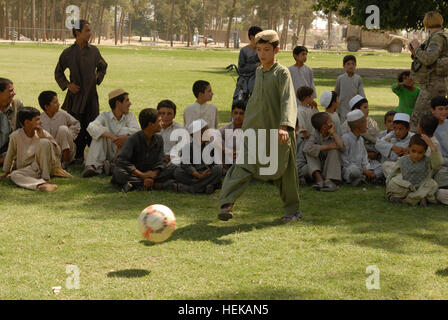 KANDAHAR, Afghanistan - spielt ein afghanischer Junge aus dem "Alten Corps" Bereich der Stadt Kandahar während ein Fußballspiel zwischen zwei lokalen Teams 8. Juni mit einem neuen Fußball. Das Spiel kam nach einem Banddurchtrennungszeremonie die Einweihung eines neuen Fußball-Felds in einem Ortsteil der Stadt Kandahar bedeutete. Das neue Feld war eines von vielen Projekten, die unter der Leitung von 1st Brigade Combat Team, TF "Raider", 4. US-Infanteriedivision und ihre afghanischen nationalen Sicherheitskräfte Partner bei ihren gemeinsamen Wiederaufbau Bemühungen zur Verbesserung der Lebensqualität und Sicherheit für die Bewohner der Stadt Kandahar. (US-Armee Stockfoto