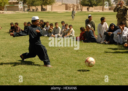 KANDAHAR, Afghanistan - spielt ein afghanischer Junge aus dem "Alten Corps" Bereich der Stadt Kandahar während ein Fußballspiel zwischen zwei lokalen Teams 8. Juni mit einem neuen Fußball. Das Spiel kam nach einem Banddurchtrennungszeremonie die Einweihung eines neuen Fußball-Felds in einem Ortsteil der Stadt Kandahar bedeutete. Das neue Feld war eines von vielen Projekten, die unter der Leitung von 1st Brigade Combat Team, TF "Raider", 4. US-Infanteriedivision und ihre afghanischen nationalen Sicherheitskräfte Partner bei ihren gemeinsamen Wiederaufbau Bemühungen zur Verbesserung der Lebensqualität und Sicherheit für die Bewohner der Stadt Kandahar. (US-Armee Stockfoto