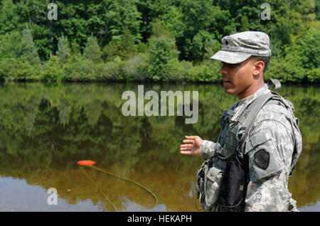 US Army Reserve Spc. Franklin Baez, ein Wasser-Reinigung-Spezialist mit 973rd Quartermaster Company, zeigt, wie Wasser aus ein Teich wird mit einem Delphin Sieb extrahiert oder schwimmende Ansaugfilter, um das Wasser während der Quartiermeister flüssig Logistik Übung zu behandeln, durchgeführt vom 1-17. Juni. Baez erklärt die Vorgehensweise für Verbrauchsmaterialien Wasser unter Verwendung der Reverse Osmose-Wasser-Reinigung Einheit zu produzieren. "Wasserhund" Pumpe sauberes Wasser bei der jährlichen Quartiermeister liquid Logistics Übung 415302 Stockfoto