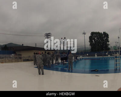 US-Soldaten zugewiesen, Hauptsitz und zentrale Batterie, 210. Fires Brigade, 2nd Infantry Division leiten Wasser überleben Kampftraining am Hanson Pool Camp Casey, Südkorea, 12. Juli 2013. Das Training brachte Soldaten reagieren auf unerwartete Wasser Landungen oder Fahrzeug Roll-Overs, darunter von einer 3-Meter-Plattform springen, Ausrüstung, während im Wasser entfernen und aufblasen Uniformen um Auftrieb zu erhöhen.  (US Armee-Foto von Han-byeol/Released) Bekämpfung von Wasser Überlebenstraining 130712-A-WG463-017 Stockfoto