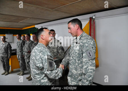 Oberst Paul Calvert, links, Kommandeur der 2. beraten und unterstützen Brigade der 1. US-Infanteriedivision, US-Division-Center und ein Athen, Georgia, native, schüttelt Hände mit 1st Lt. Jared Viernes, Recht, Zugführer mit 1. Bataillon, 63. Armor Regiment, 2. AAB, 1. inf Div. USD-C und eine Selah, Wash., Native, 12. Juli 2011 im Camp Liberty, Irak, nach der Verleihung der Bekämpfung Infanterist-Abzeichen , verdient, als seine Einheit von Aufständischen mit Anti-Tank Handgranaten angegriffen wurde. Viernes führte die Patrouille und ist als Gegenleistung für zusätzliche Dekorationen in Anerkennung seiner Führung follo Stockfoto