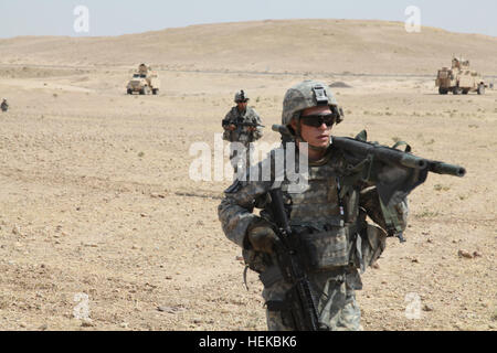 US-Armee Soldaten, 4. Geschwader, 9. Kavallerie-Regiment, 2. Brigade, 1. Kavallerie-Division, Ansturm auf eine Mine Resistant Ambush Protected Fahrzeug während der Medic Übungen vorzubereiten ein Opfer für medizinische Evakuierung bei Forward Operating Base Cobra in der Provinz Diyala, Irak, 12 Juli. Die Soldaten führen diese Bohrmaschine, so werden sie im Falle einer echten Medevac-Szenario vorbereitet sein. (US Armee-Foto von Pfc. Nikko-Angelo Matos) Medic Übung 110712-A-YV529-001 Stockfoto