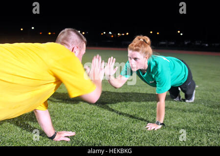 Air Force Staff Sgt Casey Glass und Petty Officer 1st Class Jerome Breaux, Logistiker, durchführen "High-Five" Push-ups 13 Juli am Naval Station Guantanamo Bay Cooper Feld und Sports Complex. Glas, brachte ein persönlicher Trainer in den Staaten ihre Leidenschaft für körperliche Fitness Soldaten der Joint Task Force Guantanamo unterstützen diejenigen, die um ihre Hilfe bitten. JTF Guantanamo bietet sichere, humane, legale, transparente Pflege und Obhut der Gefangenen, einschließlich der Militärkommission und die verurteilten freigegeben von einem Gericht angeordnete. Die JTF führt Intelligenzansammlung, Analyse und d Stockfoto