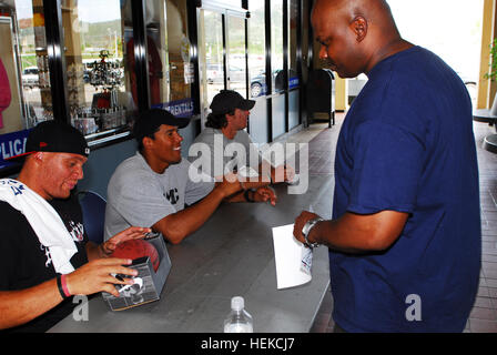 GUANTANAMO BAY auf Kuba – Navy Chief Petty Officer Quincy L. Jackson, Mitglied der Joint Task Force Guantanamo-Service Uhren Billy Miller, New Orleans Saints-Tight-End, seine Fußball am US Naval Station Guantanamo Bay, 27. Juni 2009 zu unterzeichnen. Drew Brees, Quarterback der New Orleans Saints, und Donnie Edwards, Kansas City Chiefs offensive Linebacker, nahmen ebenfalls an die Service-Organisation United Tour bereitgestellten Dienst Mitglieder zu besuchen. Die USO plant viele Meet-and-greet Veranstaltungen Service Mitglied Moral zu heben. JTF Guantanamo durchführt, sichere, humane, rechtliche und transparente Pflege und Obhut der Gewahrsam Stockfoto